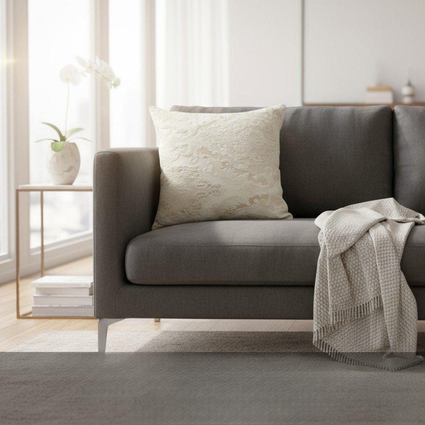 Gray sofa with a decorative pillow and blanket in a bright living room.