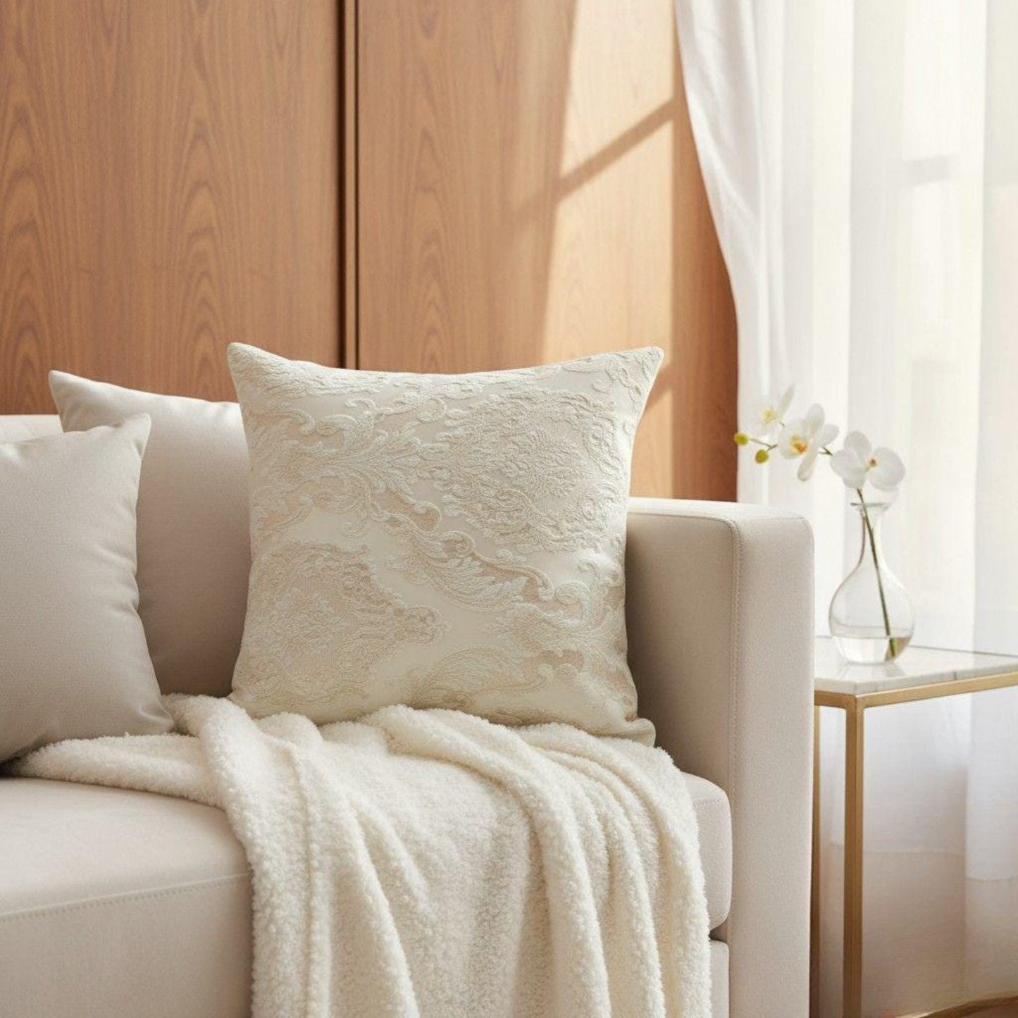 Beige sofa with textured pillows and a blanket in a bright room.
