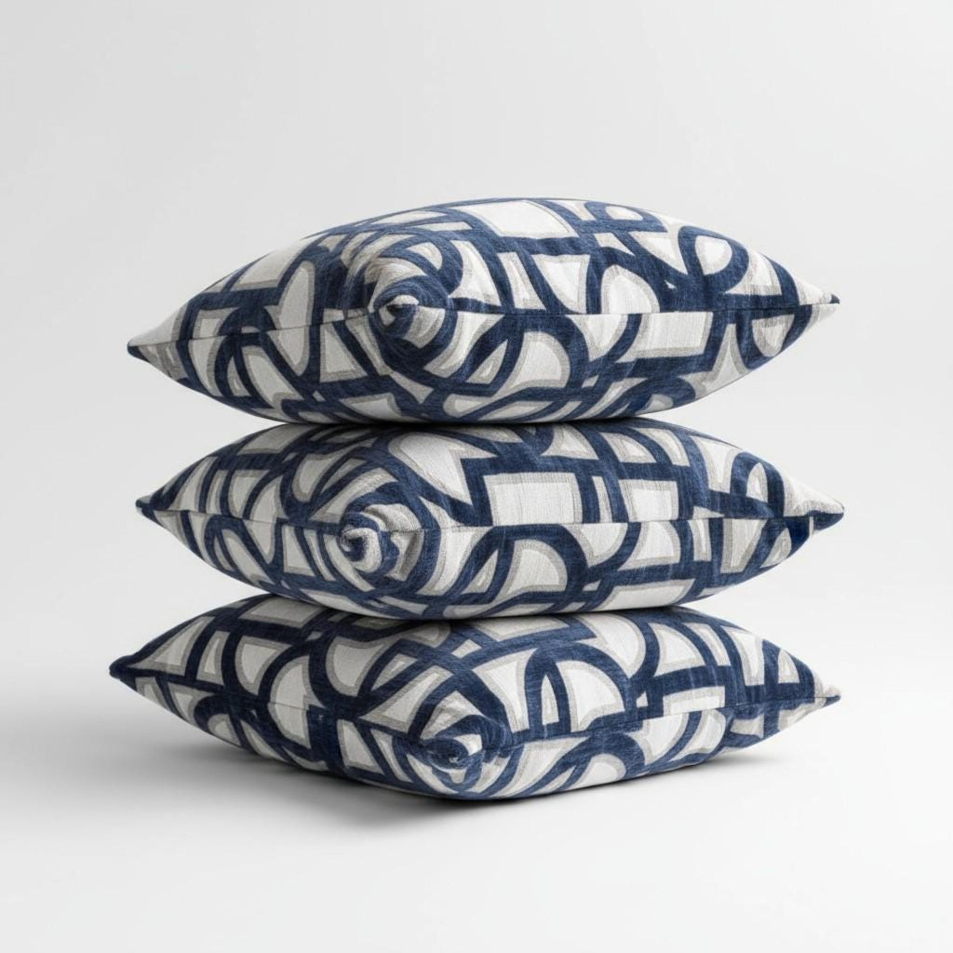 Three decorative pillows with blue and white pattern on a light gray background