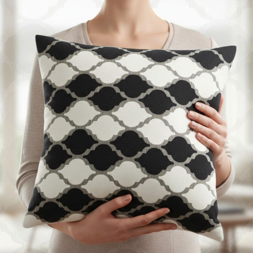 Person holding a black and white patterned pillow